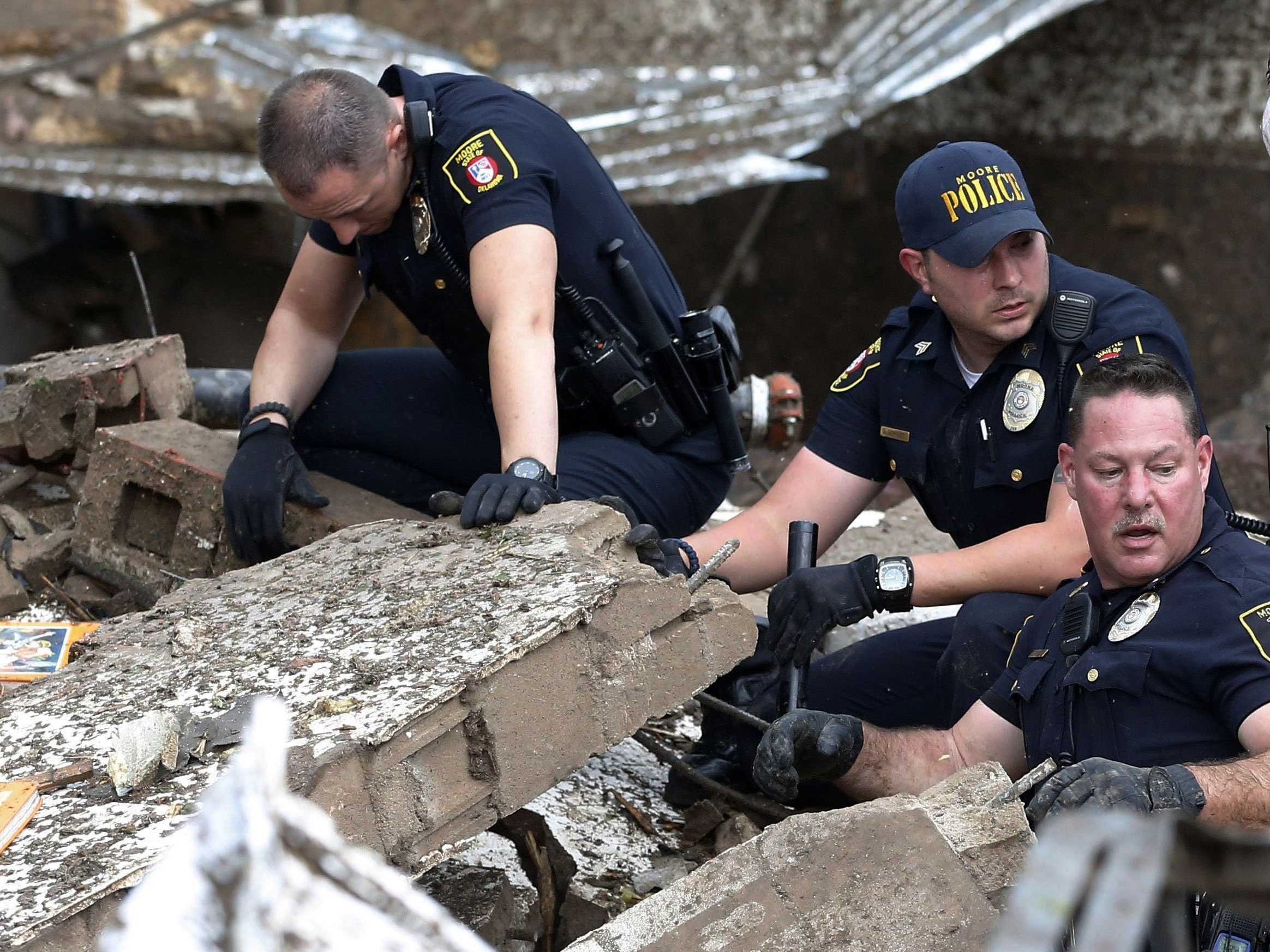 Moore police dig through the rubble of the Plaza Towers Elementary School following a tornado in Moore, Okla., Monday, May 20, 2013  Photo Copyright AP